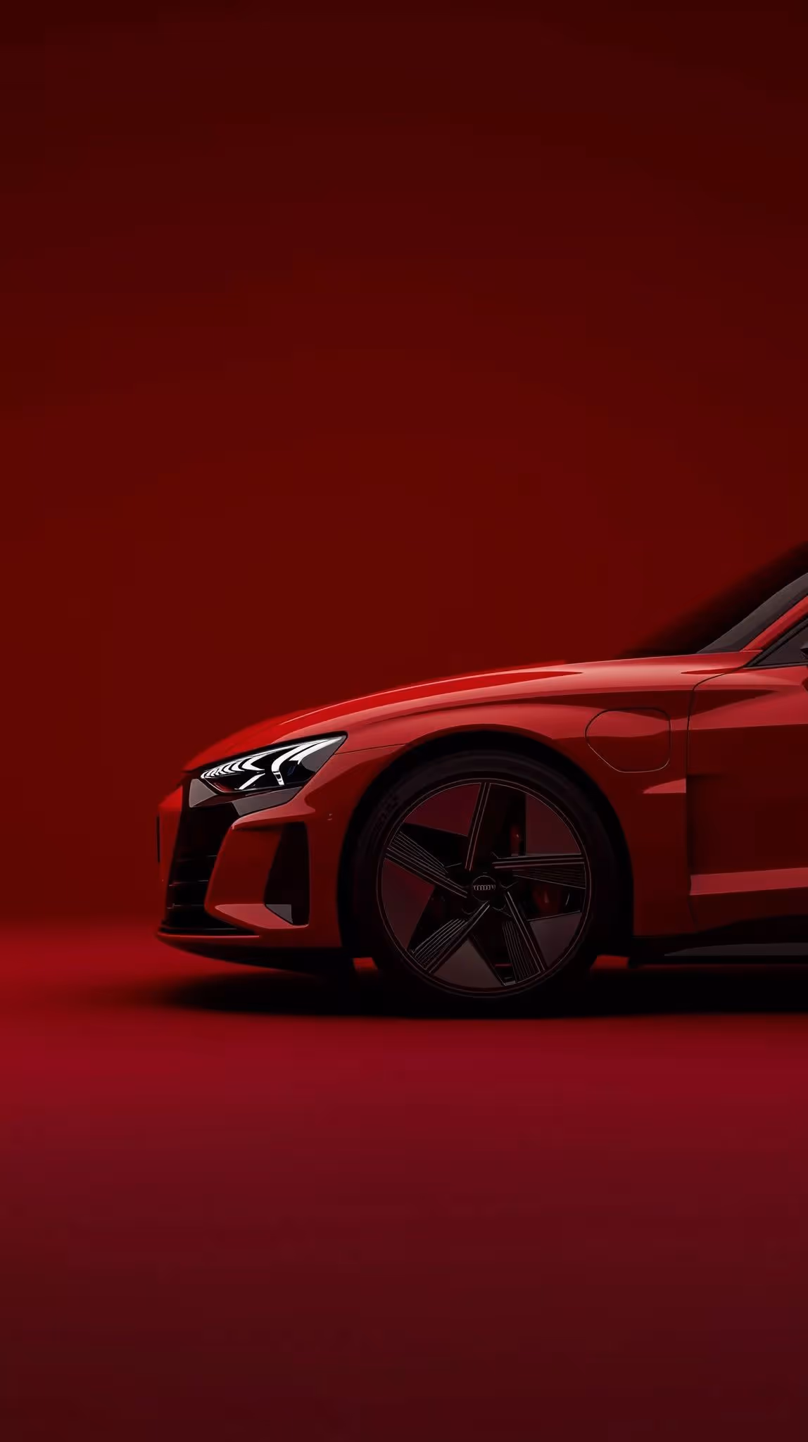 Side view of a red sports car front end with illuminated headlight on a red background.