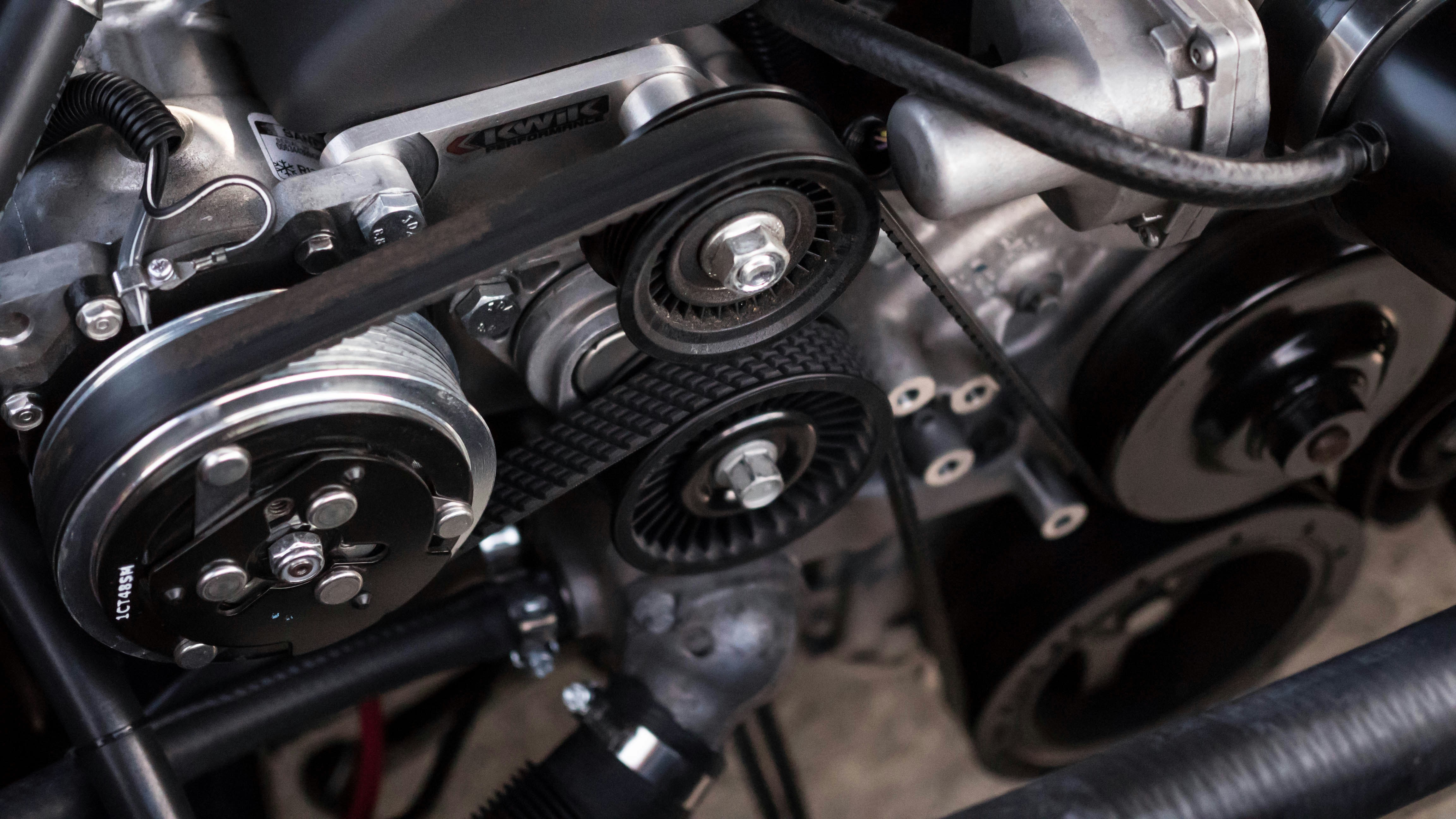 Close-up of mechanical components with belts and pulleys in an engine.