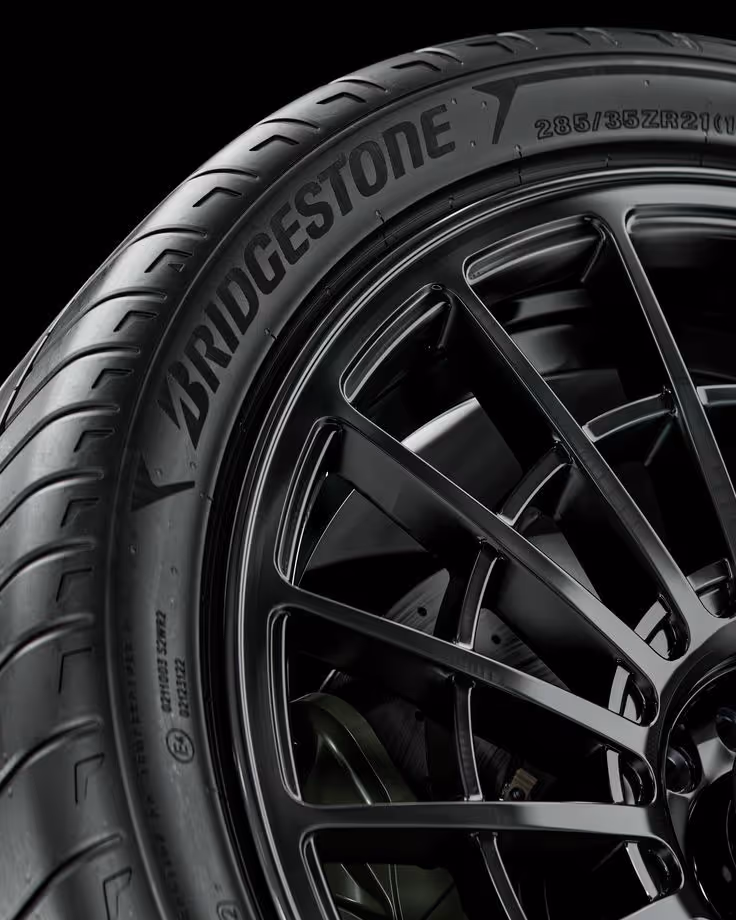 Close-up of a Bridgestone tire mounted on a black alloy wheel with detailed rim spokes.