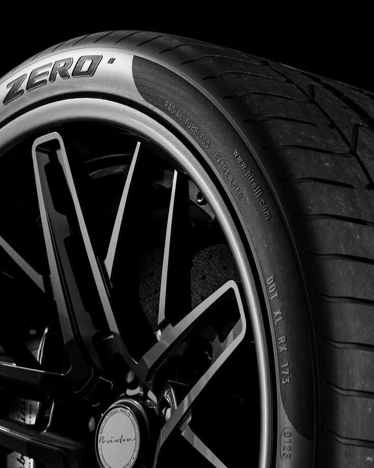 Close-up of a black car tire with the word 'ZERO' embossed on the sidewall and a stylish black alloy wheel.
