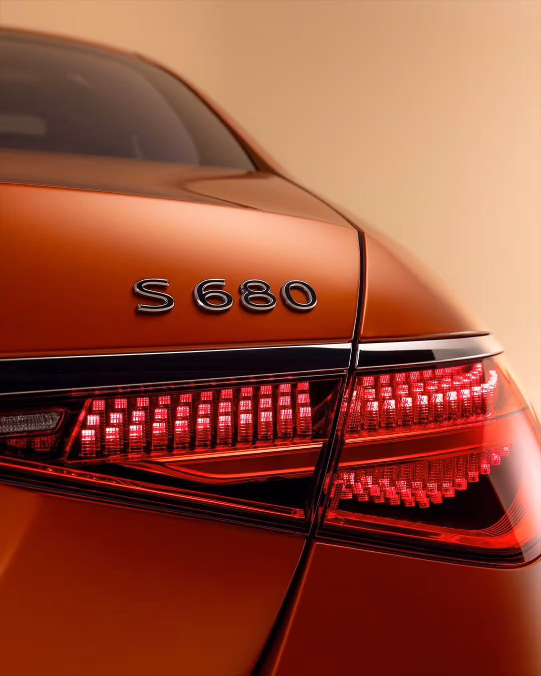 Close-up of a red car's rear with S 680 badge and illuminated tail light.