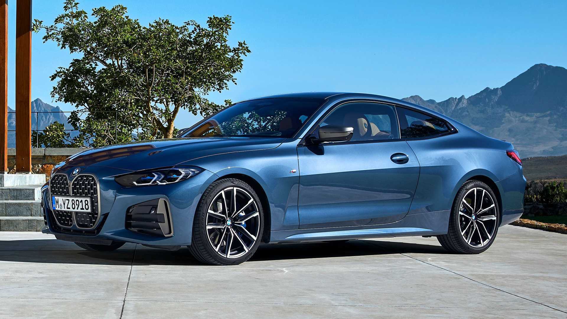 Blue BMW 4 Series coupe parked outdoors with mountains and clear sky in the background.
