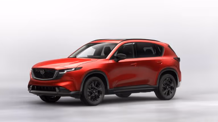 Red Mazda CX-5 SUV with black wheels and trim against a plain light gray background.